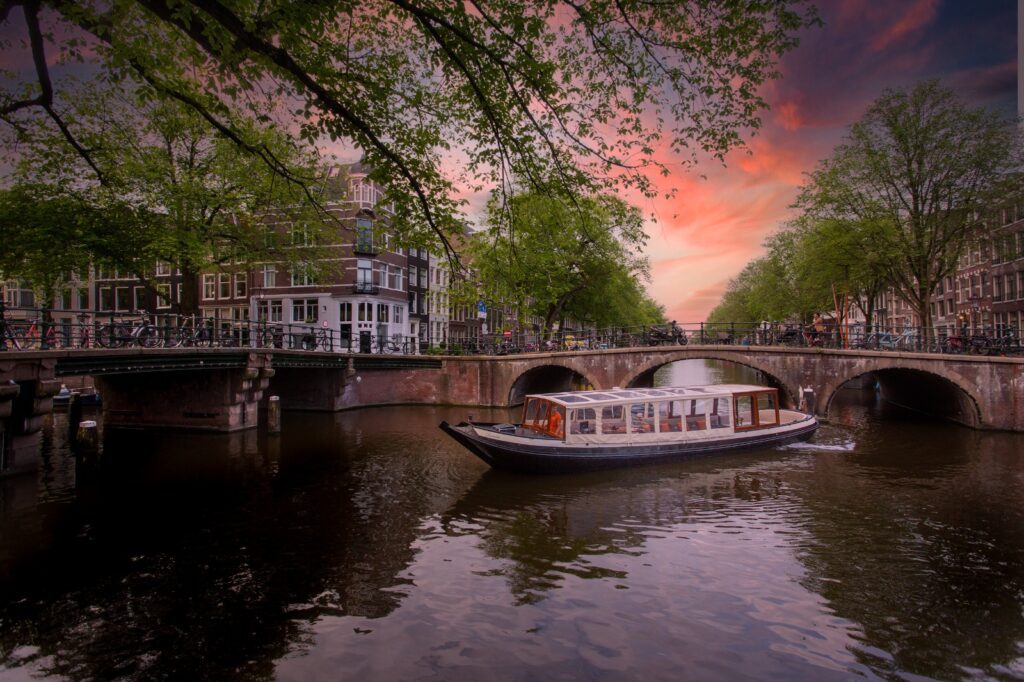 Een boot op de Amsterdamse grachten tijdens zonsondergang voor een diner rondvaart Amsterdam.