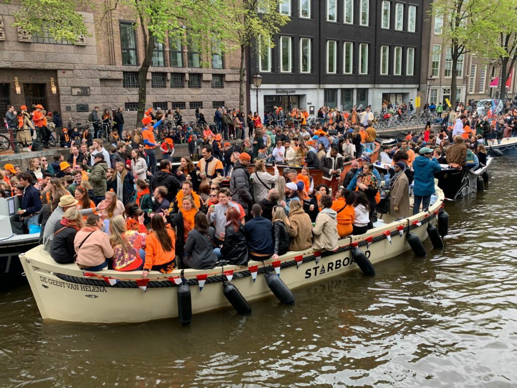 Mensen op een boot, in het oranje gekleed tijdens Koningsdag