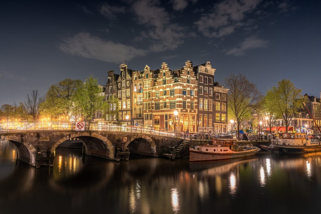 Amsterdamse grachten en brug in de avond helemaal belicht tijdens een rondvaart Amsterdam. 