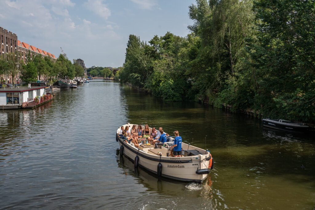 Een boot op de Amsterdamse grachten met mensen die genieten van een lunch