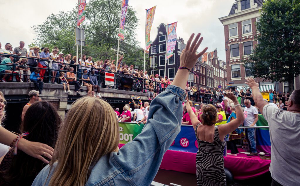 Mensen aan het feesten op de grachten tijdens de canal parade Amsterdam.