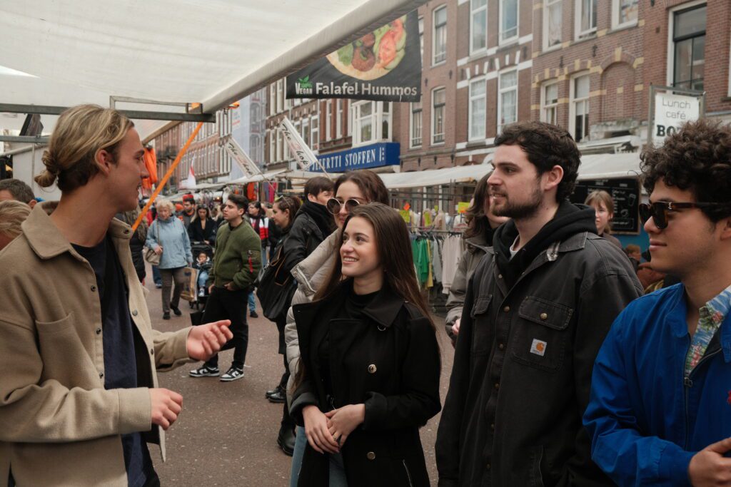 People listening to a tour guide talking about the local cuisine during a food tour Amsterdam.