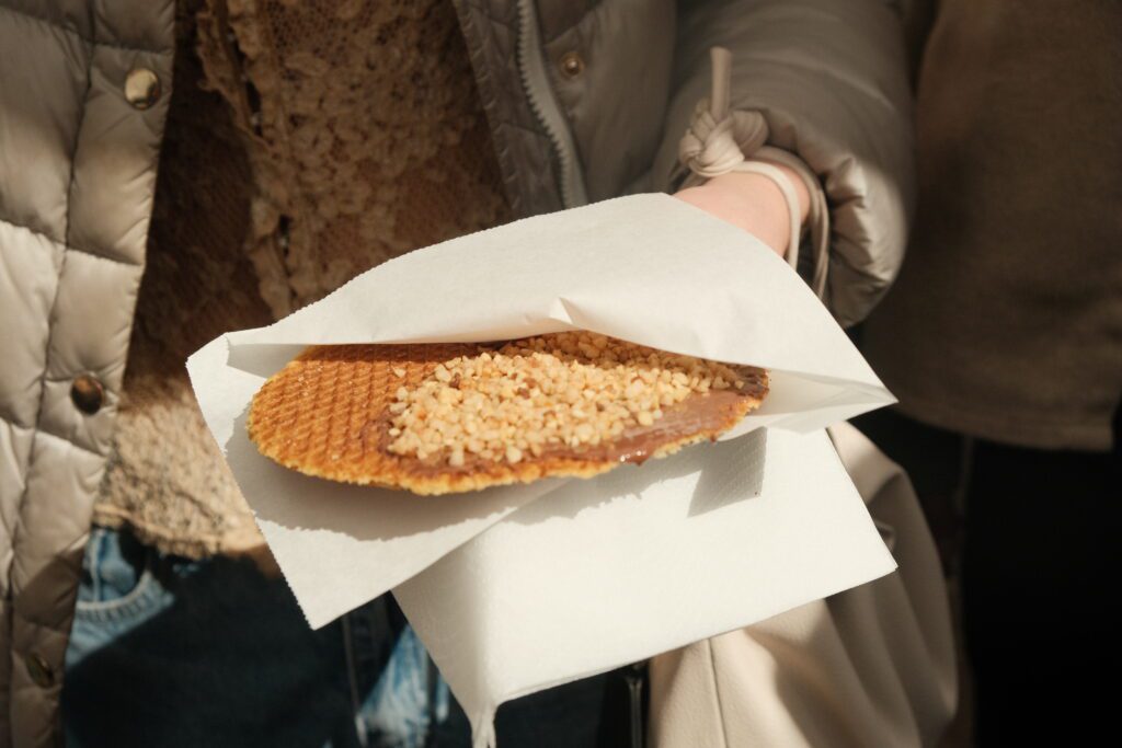 Close up of a person holding a traditional 'stroopwafel'