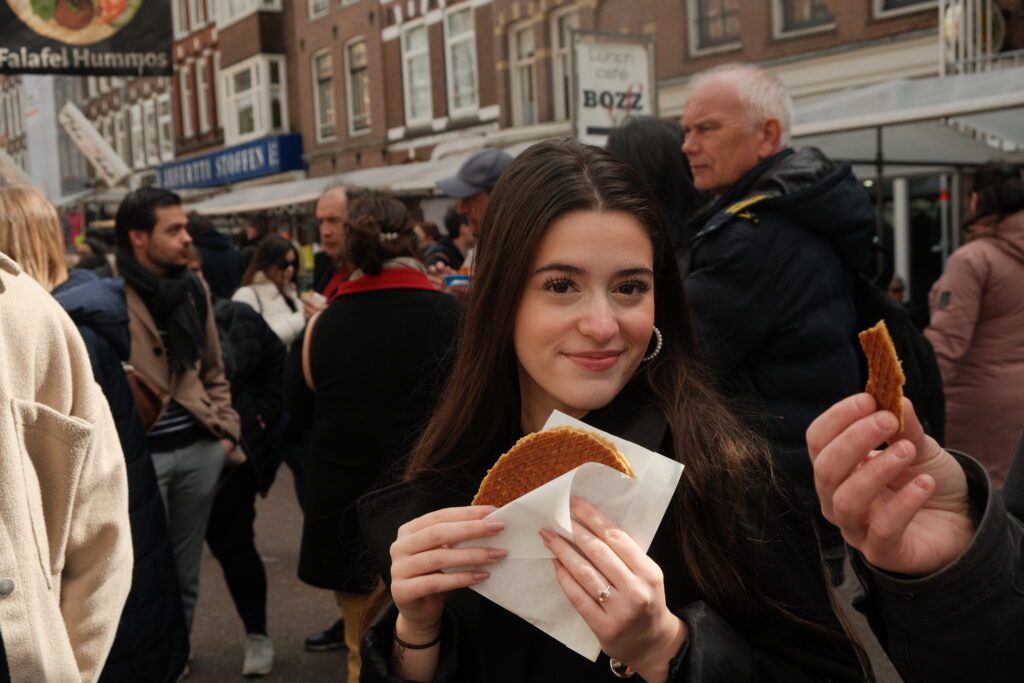 A girl posing with a stroopwafel on a market in Amsterdam